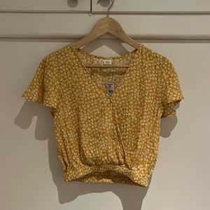 womans yellow blouse with white flowers